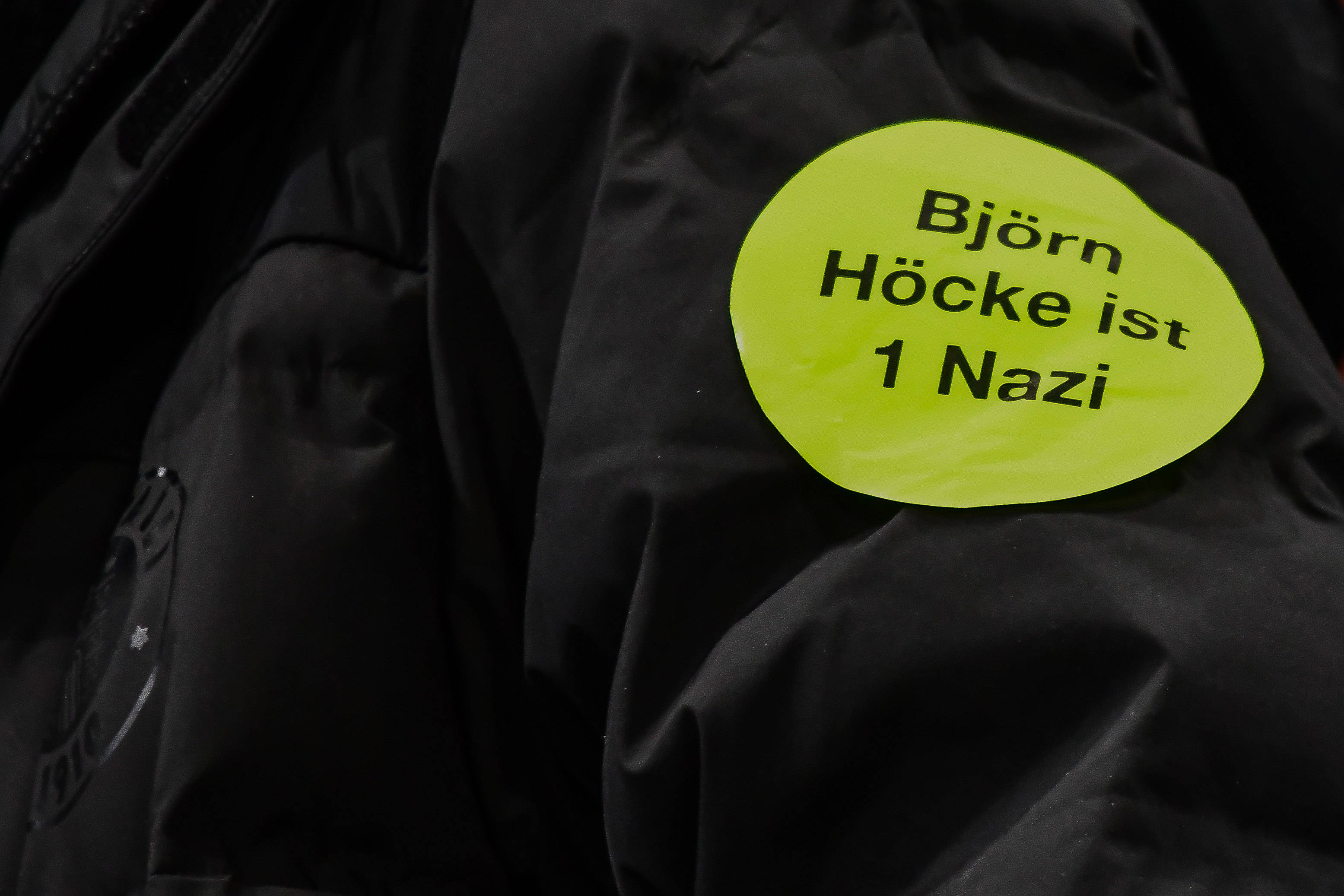 Ein Anhänger des Fußball-Zweitligisten FC St. Pauli trägt einen Aufkleber mit der Aufschrift „Björn Höcke ist 1 Nazi“ auf seiner Jacke.