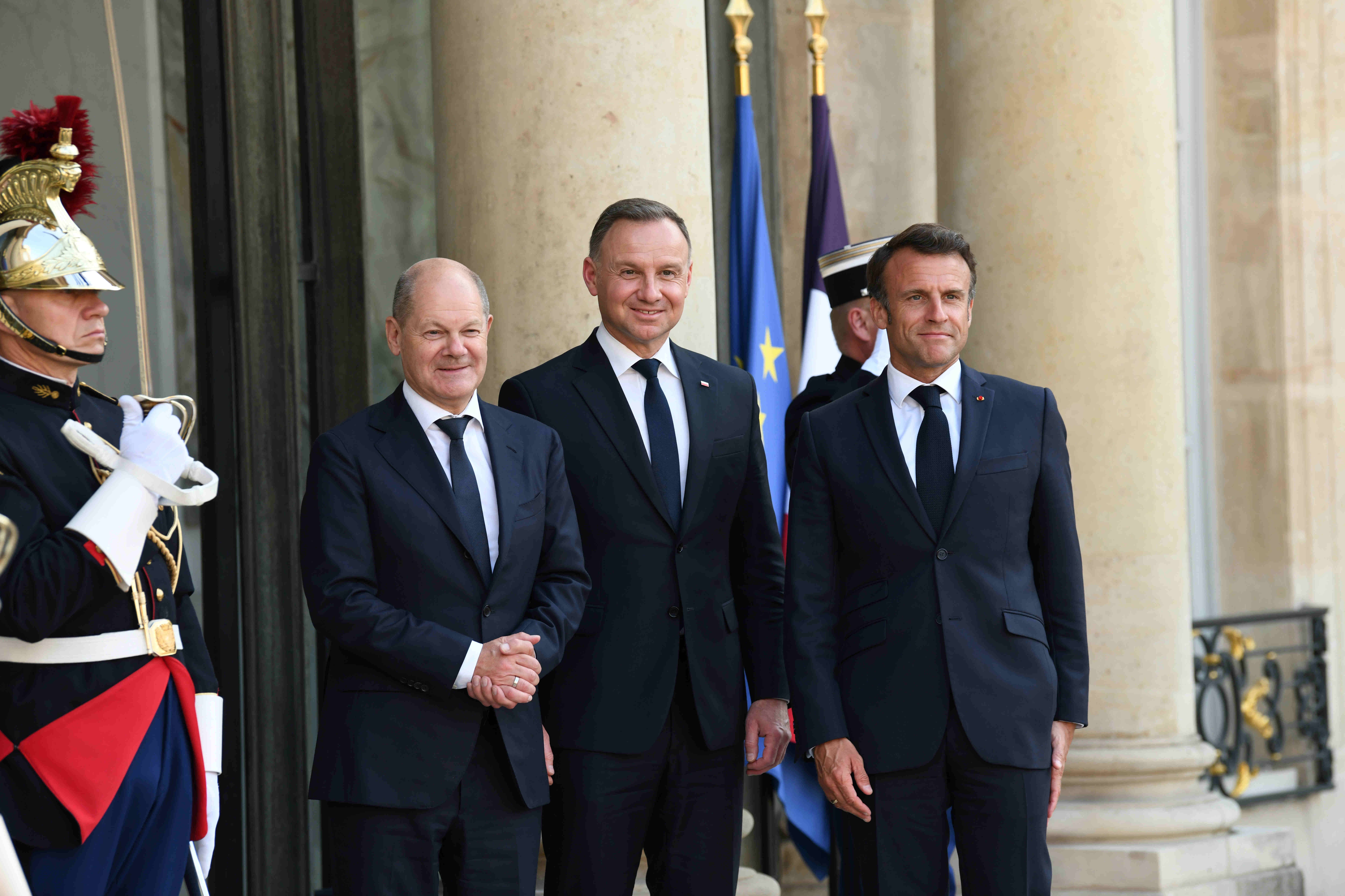 Treffen im Rahmen des Weimarer Dreiecks in Paris am 12. Juni 2023: Bundeskanzler Olaf Scholz (l.) und Präsident Andrzej Duda (m.) werden von Präsident Emmanuel Macron (r.) im Ehrenhof des Elysee-Palastes begrüßt.