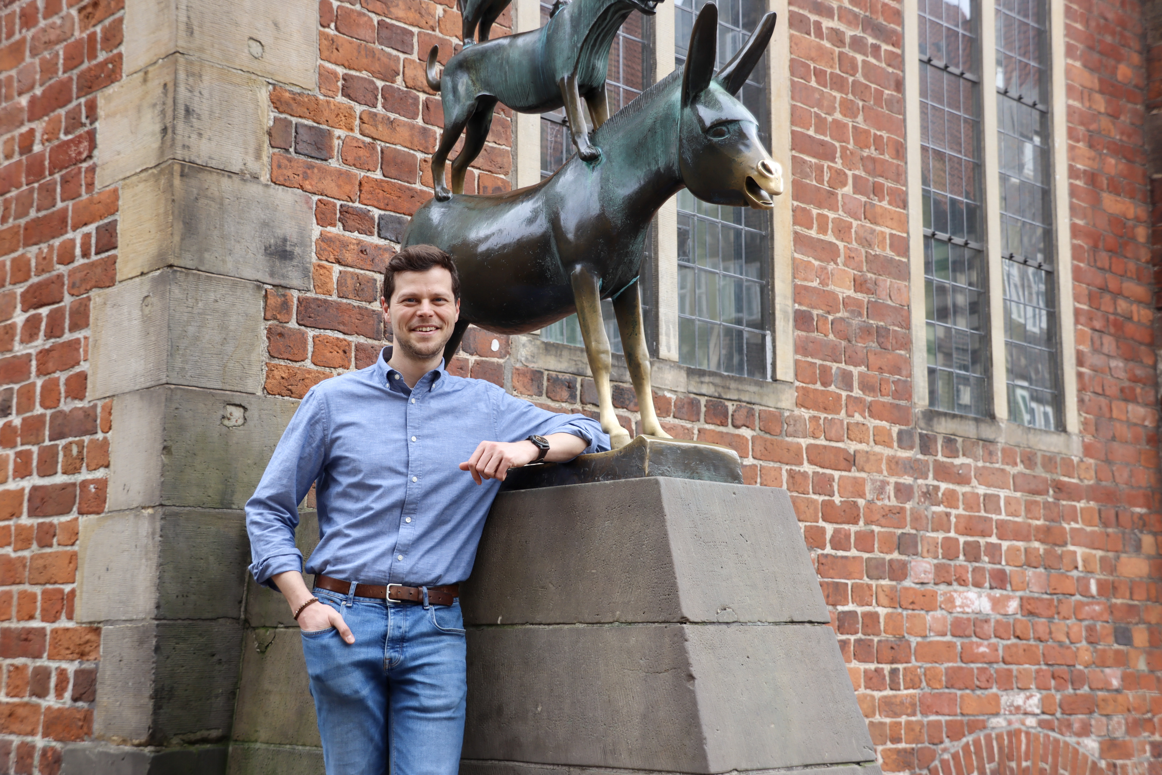 Falk Wagner posiert vor den Bremer Stadtmusikanten.