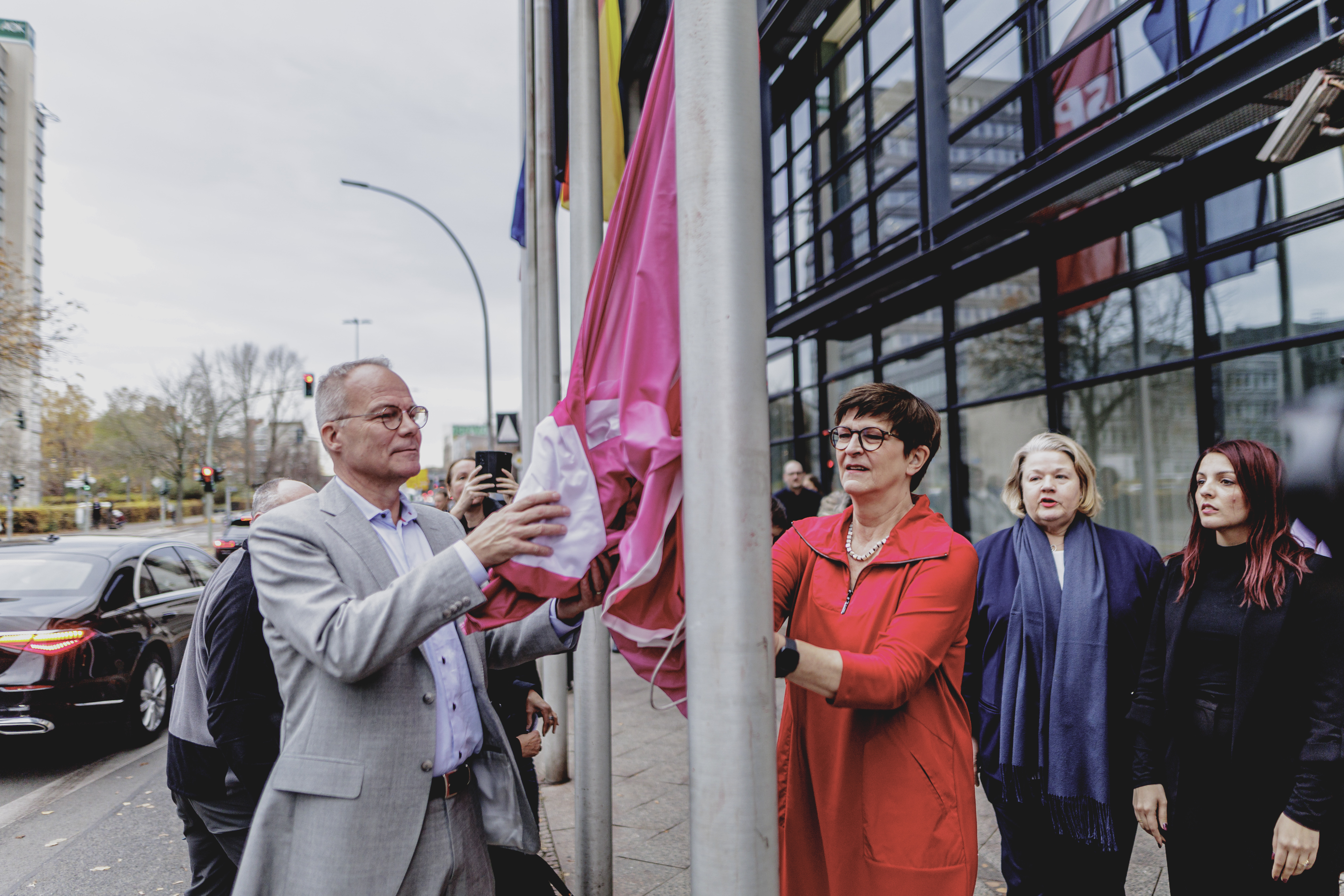 SPD-Generalsekretär Matthias Miersch (links) und SPD-Parteichefin Saskia Esken hissen die Flagge gegen Gewalt gegen Frauen vor dem Willy-Brandt-Haus in Berlin.