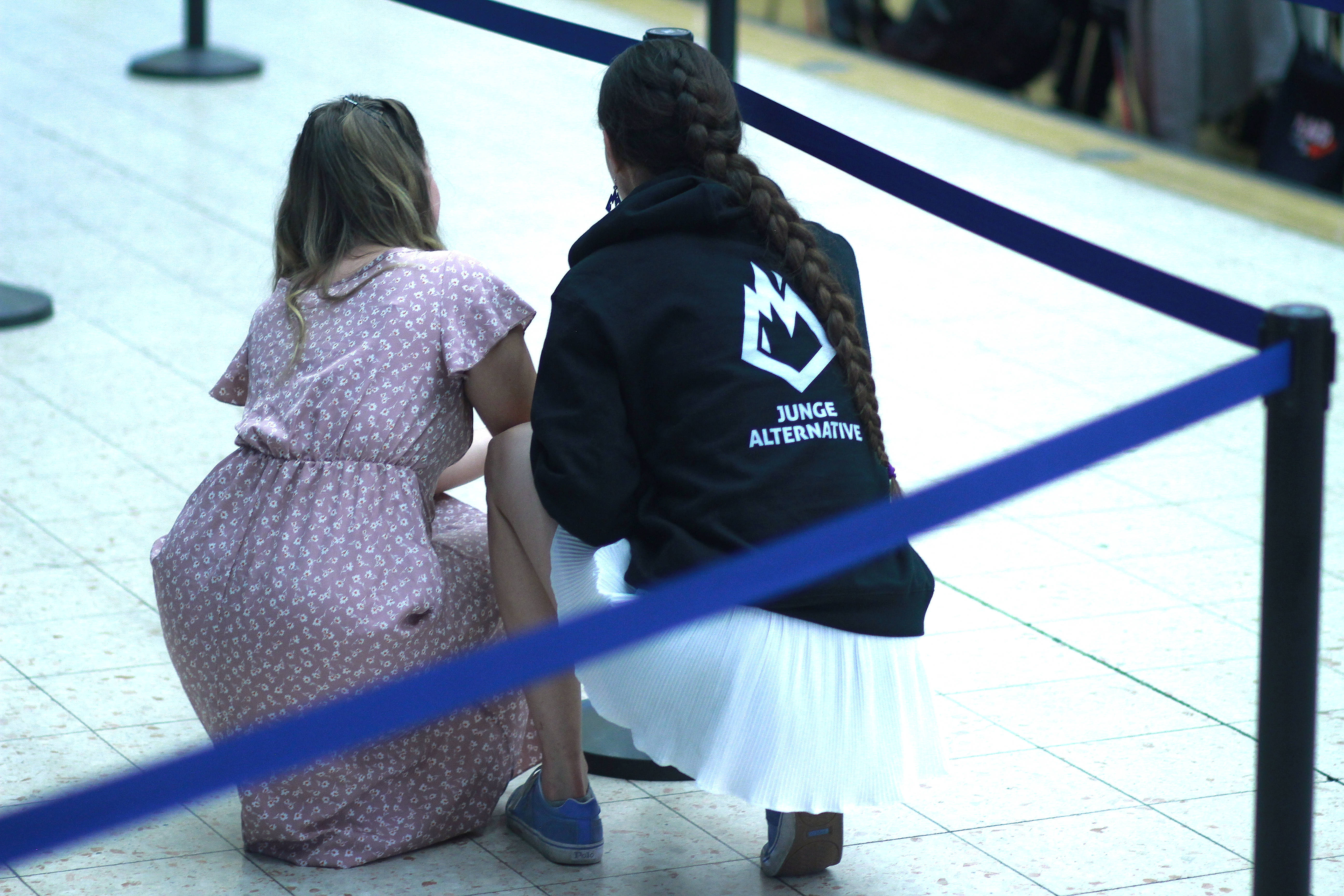 Zwei junge Frauen, eine davon mit einem Oberteil mit der Aufschrift „Junge Alternative" beim Parteitag der AfD in Essen.