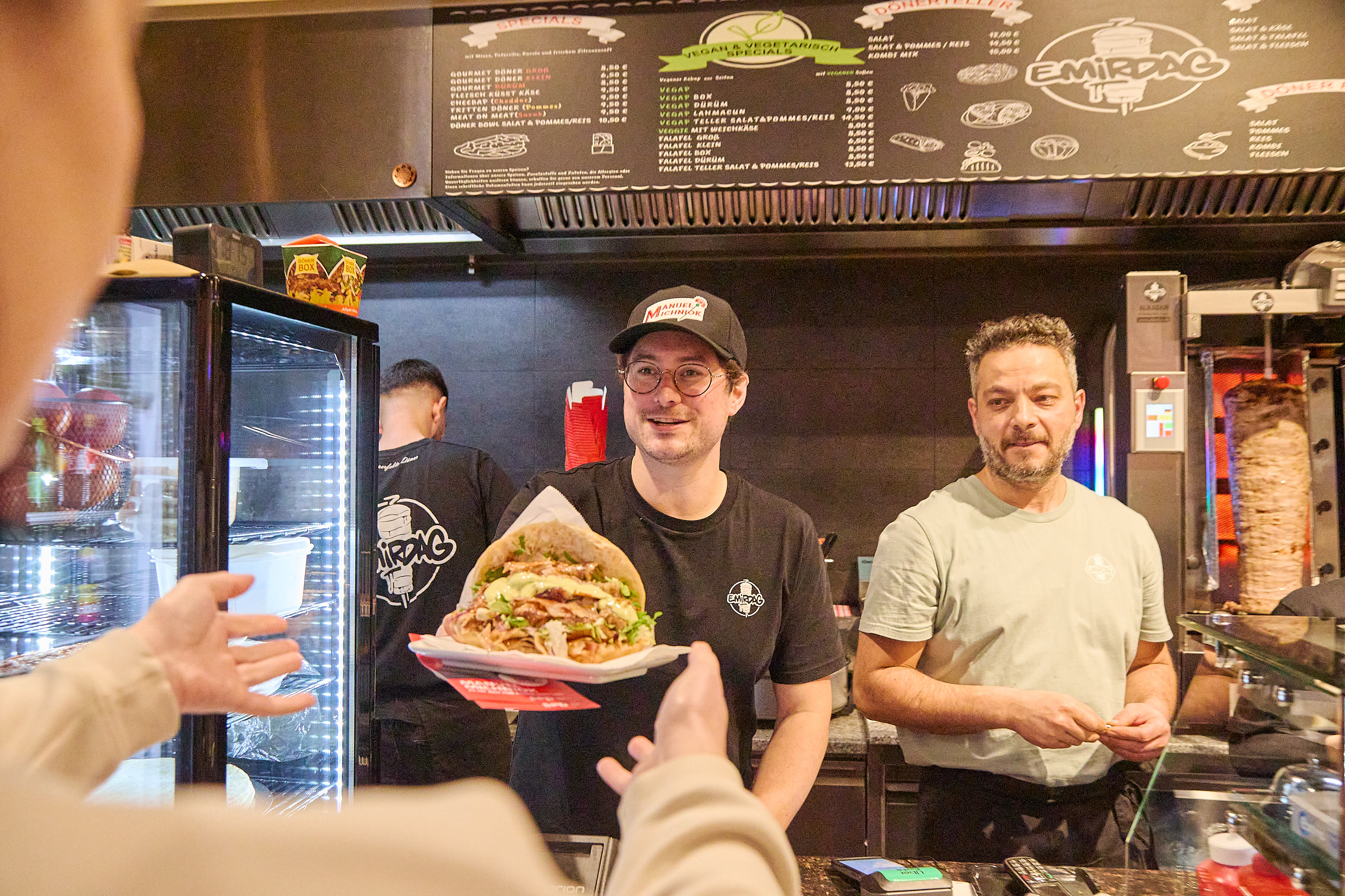 SPD-Bundestagskandidat Manuel Michniok überreicht am „Dönerstag“ in Aschaffenburg einen Döner.