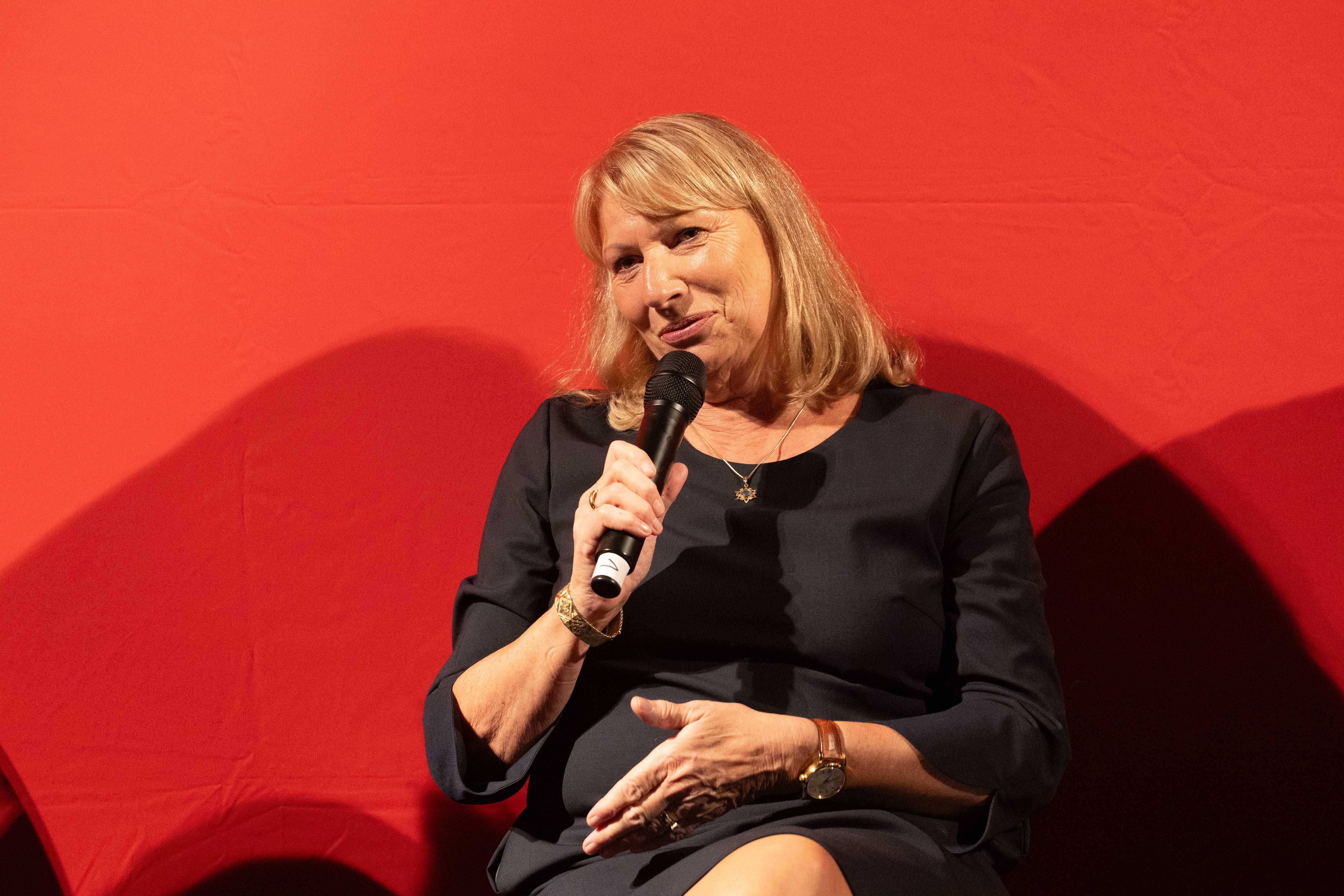 Petra Köpping (SPD) sitzt auf einem Sessel und spricht in ein Mikrofon.