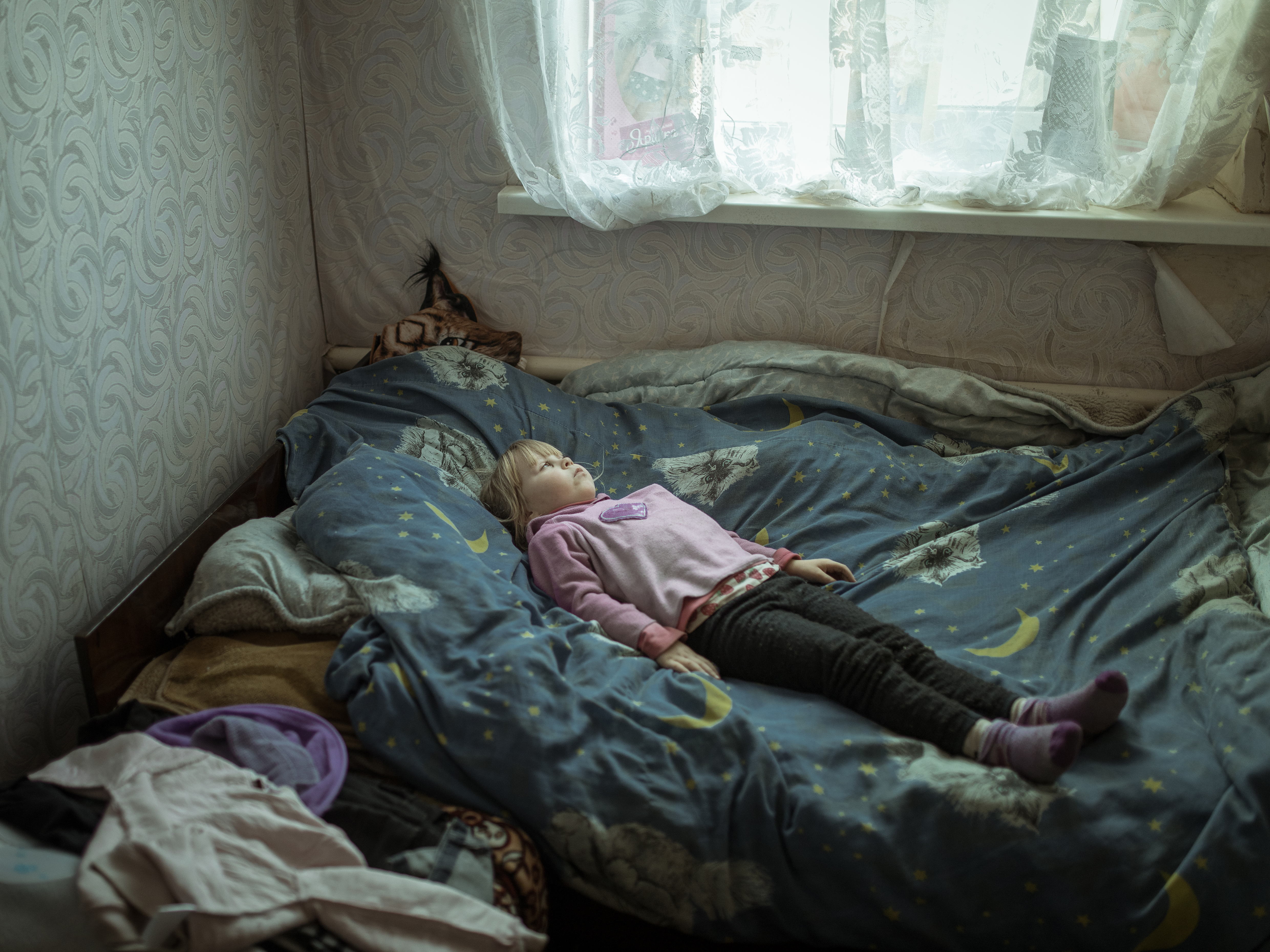 Die kleine Angelinha (6) liegt auf ihrem Bett - seit ihrer Flucht von der Front ist sie traumatisiert.