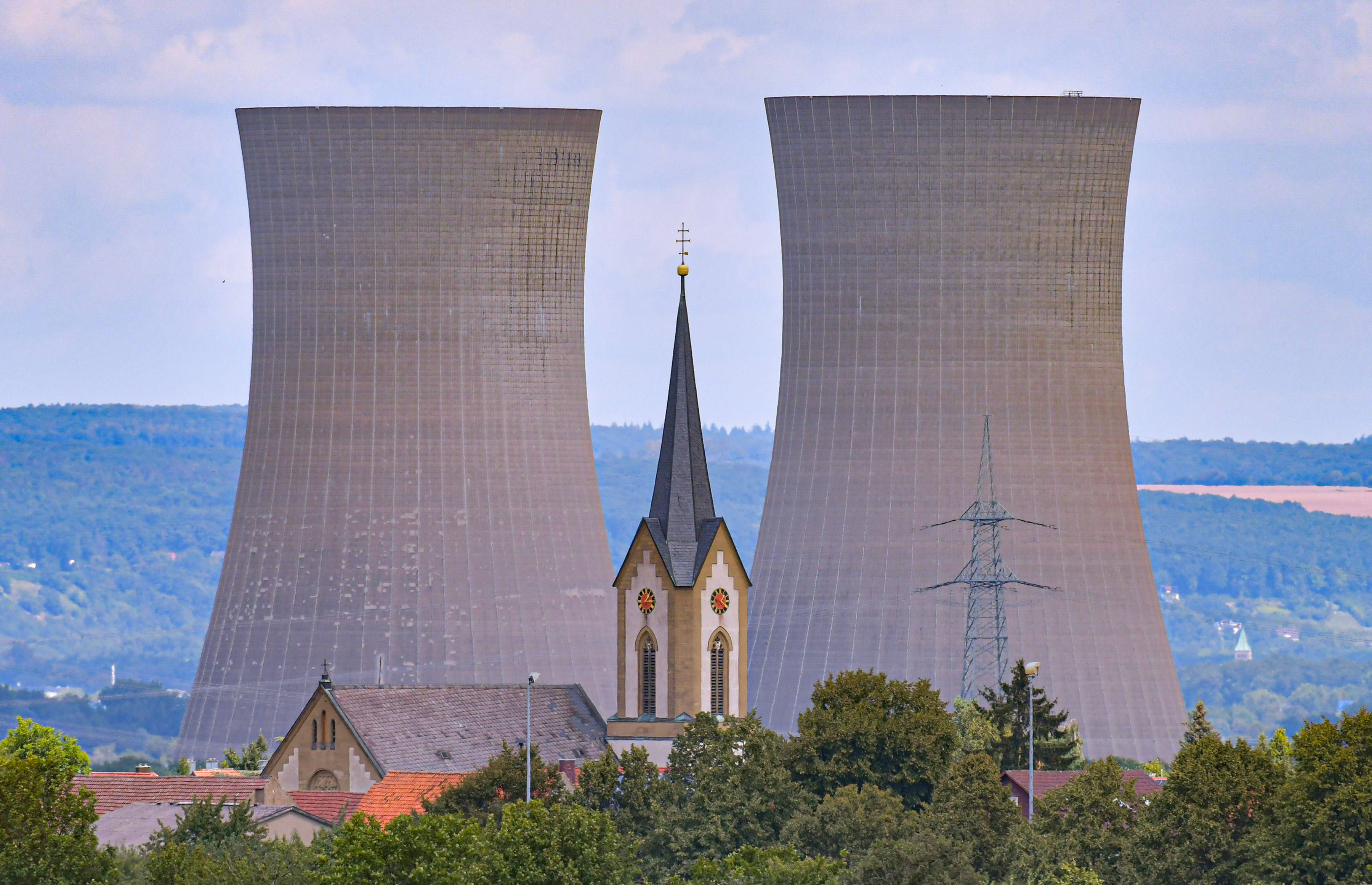 Kühltürme des – 2024 gesprengten – Atomkraftwerks Grafenrheinfeld hinter einem Kirchturm