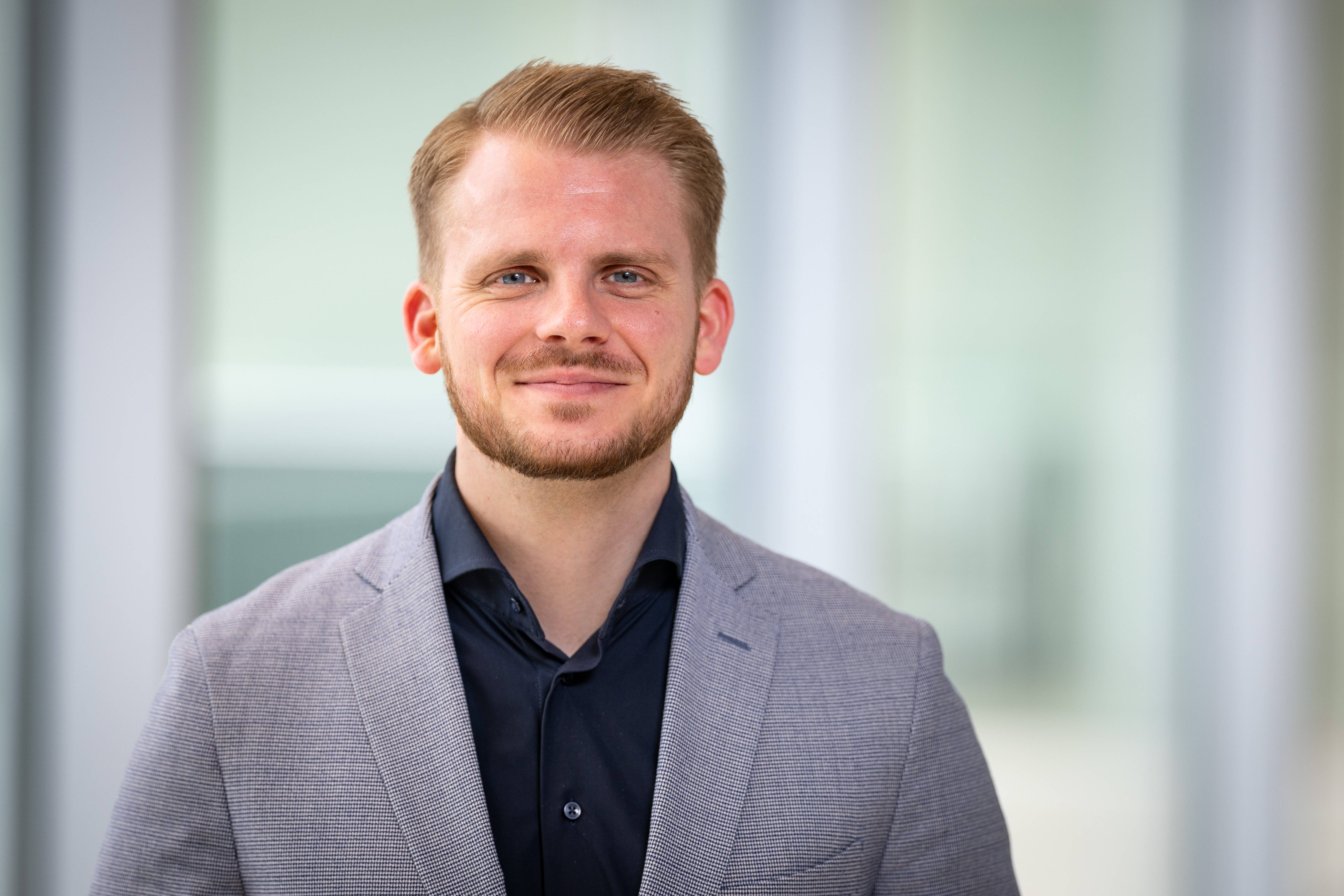 Porträt von Tim Klüssendorf, designierter SPD-Generalseketär, in schwarzem Hemd und grauem Sakko