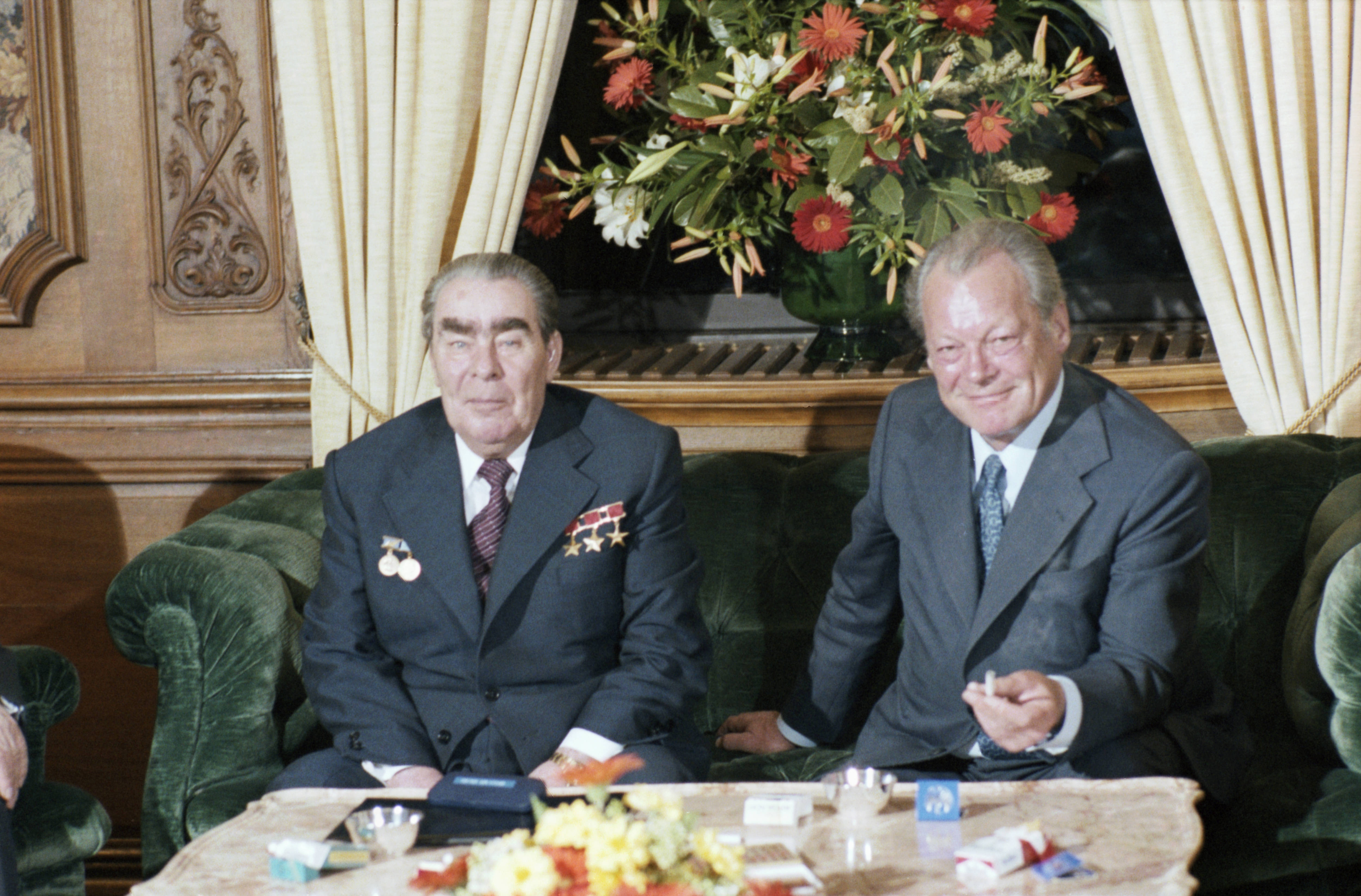 Willy Brandt und Leonid Breschnew sitzen auf einem Sofa, Farbfoto