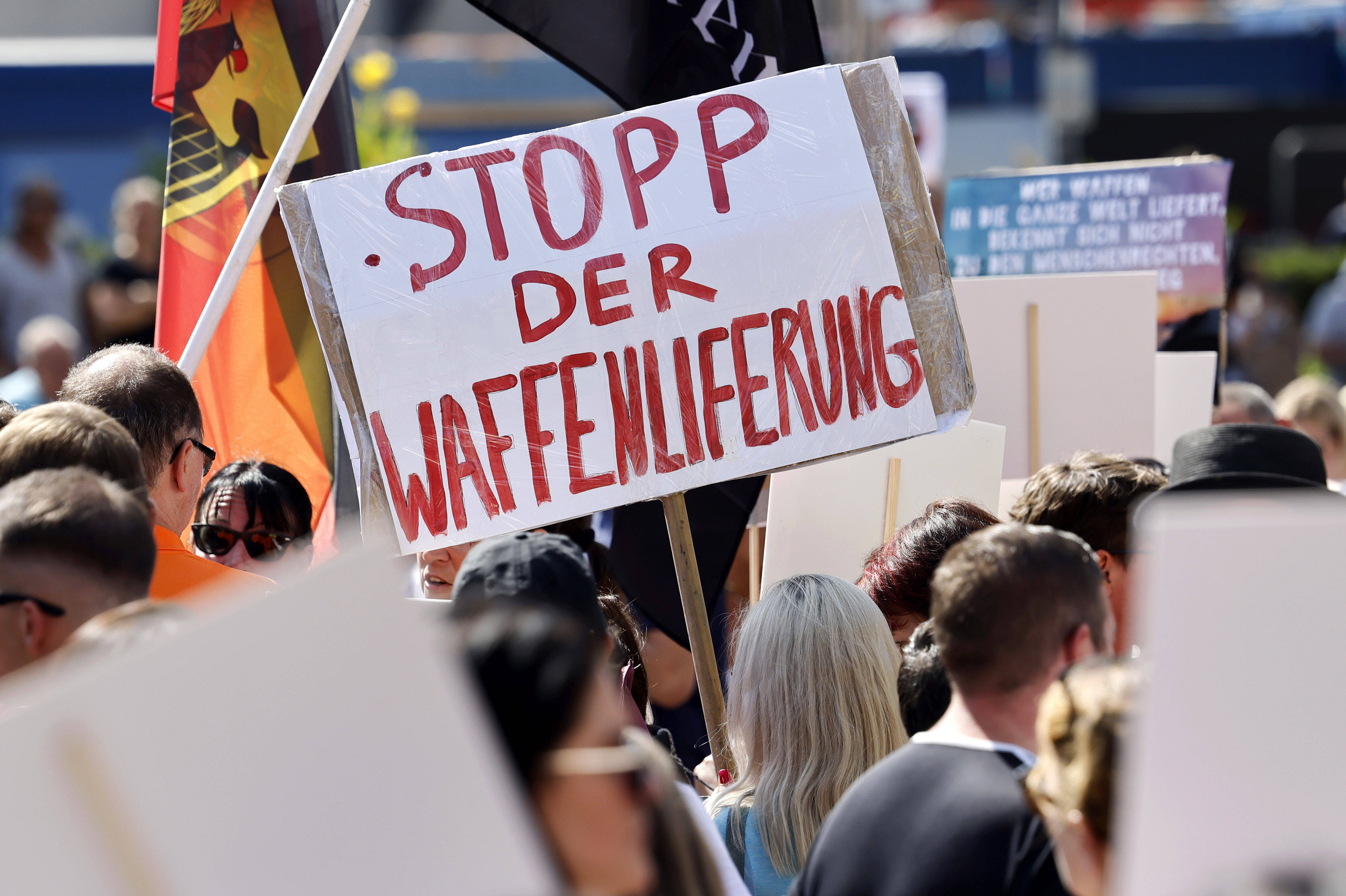 Eine Demonstrantin fordert mit ihrem Schild Stopp der Waffenlieferung.
