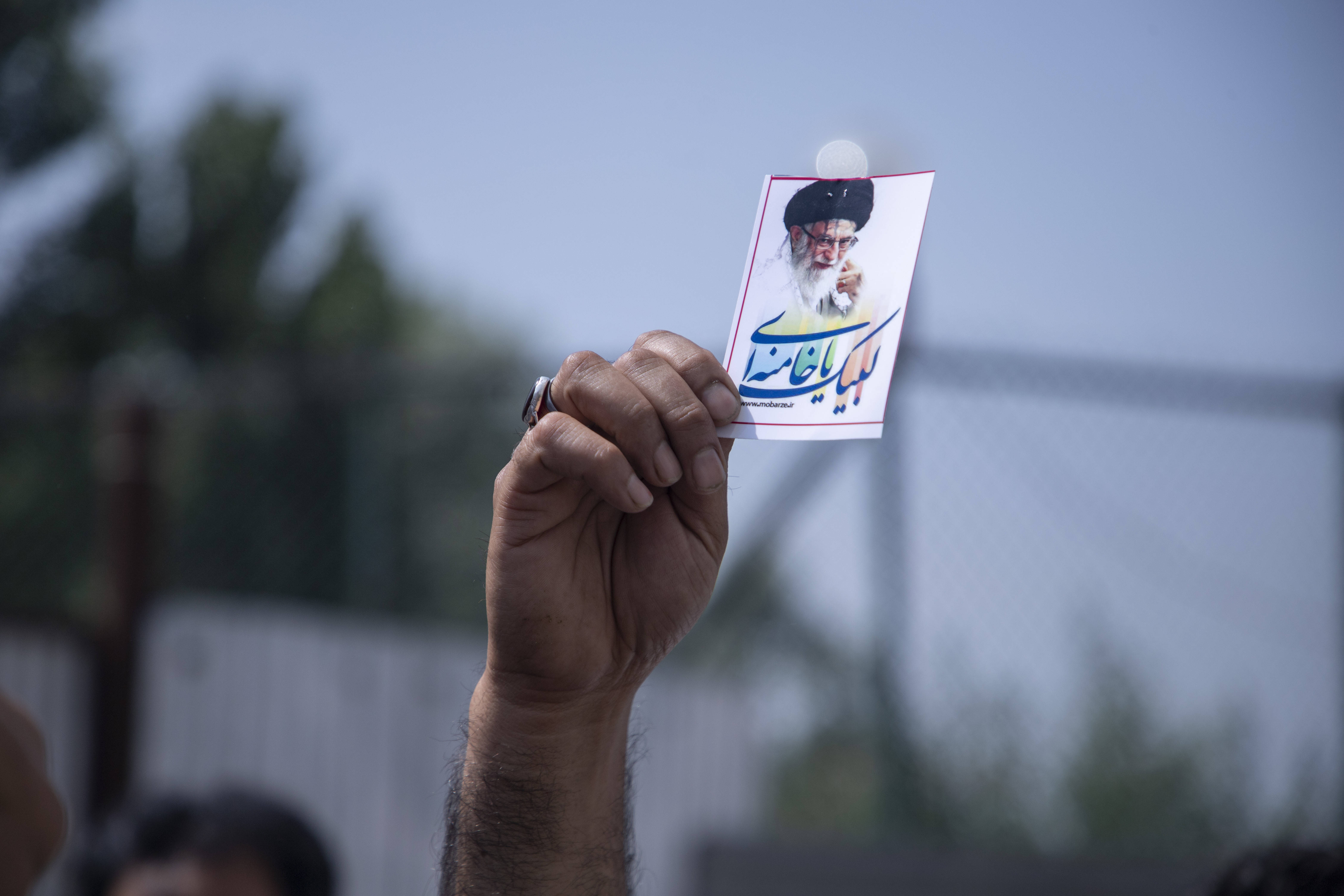 Ein Mann hält ein Porträt des Obersten Führers des Iran, Ali Khamenei.