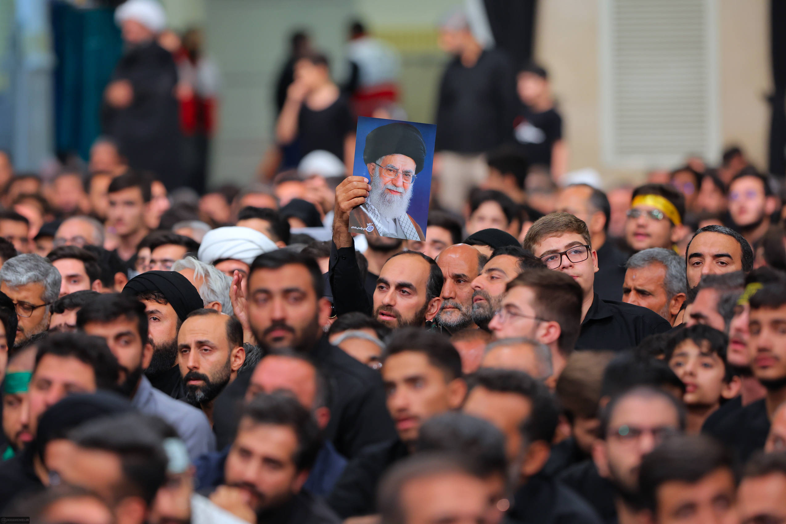 Demonstration von Männer in Teheran mit einem Porträt von Ali Khamenei
