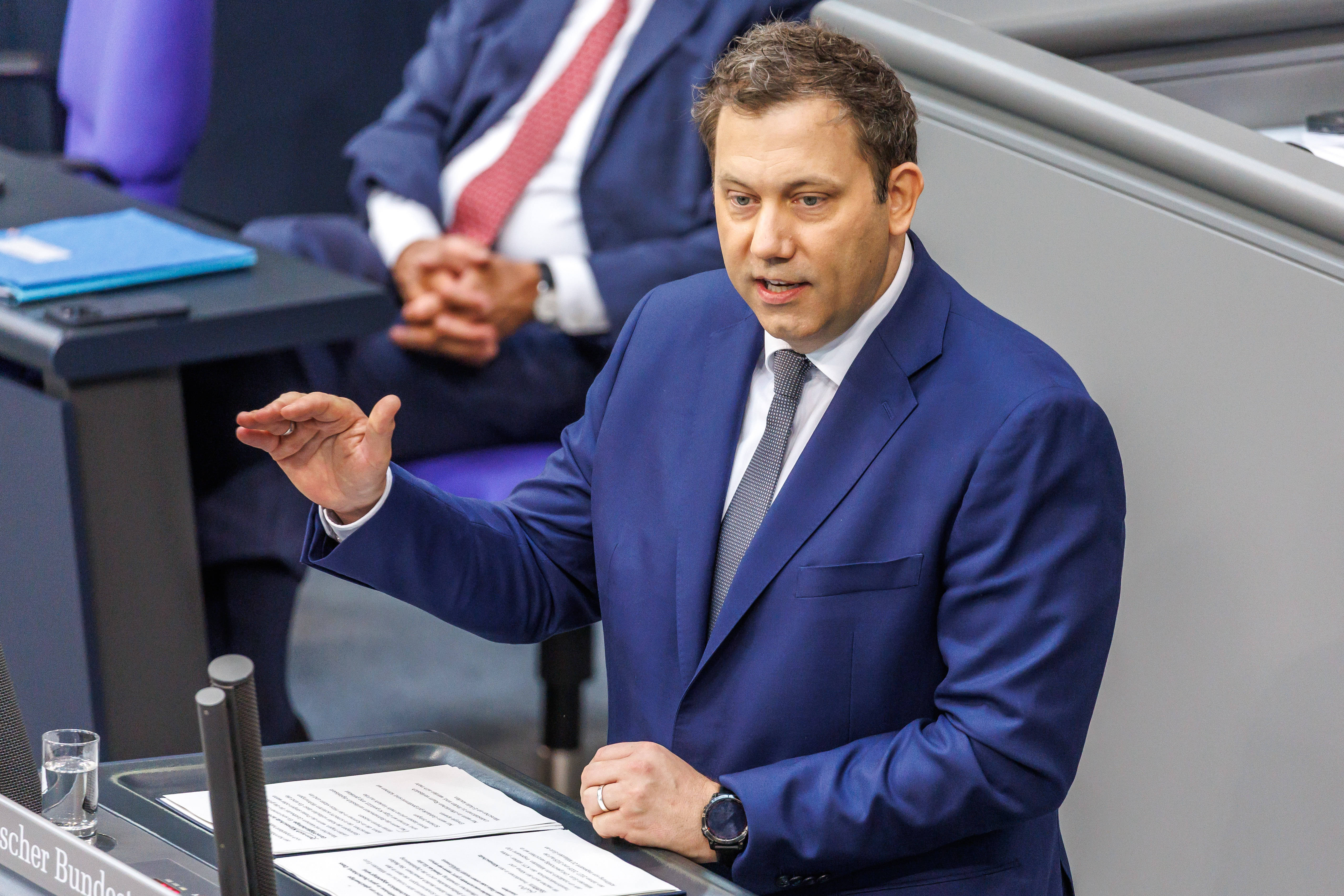 Lars Klingbeil mit erhobener Hand am Redepult im Bundestag