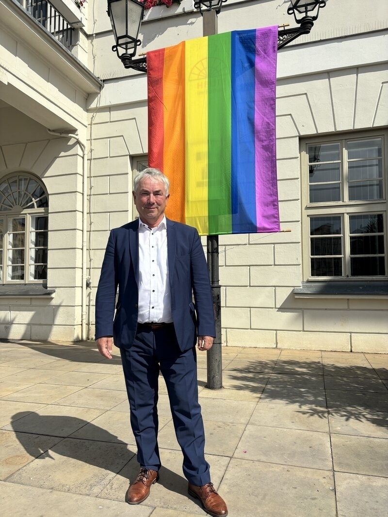 Bürgermeister Thomas Beyer vor der Regenbogenflagge am Rathaus der Stadt Wismar