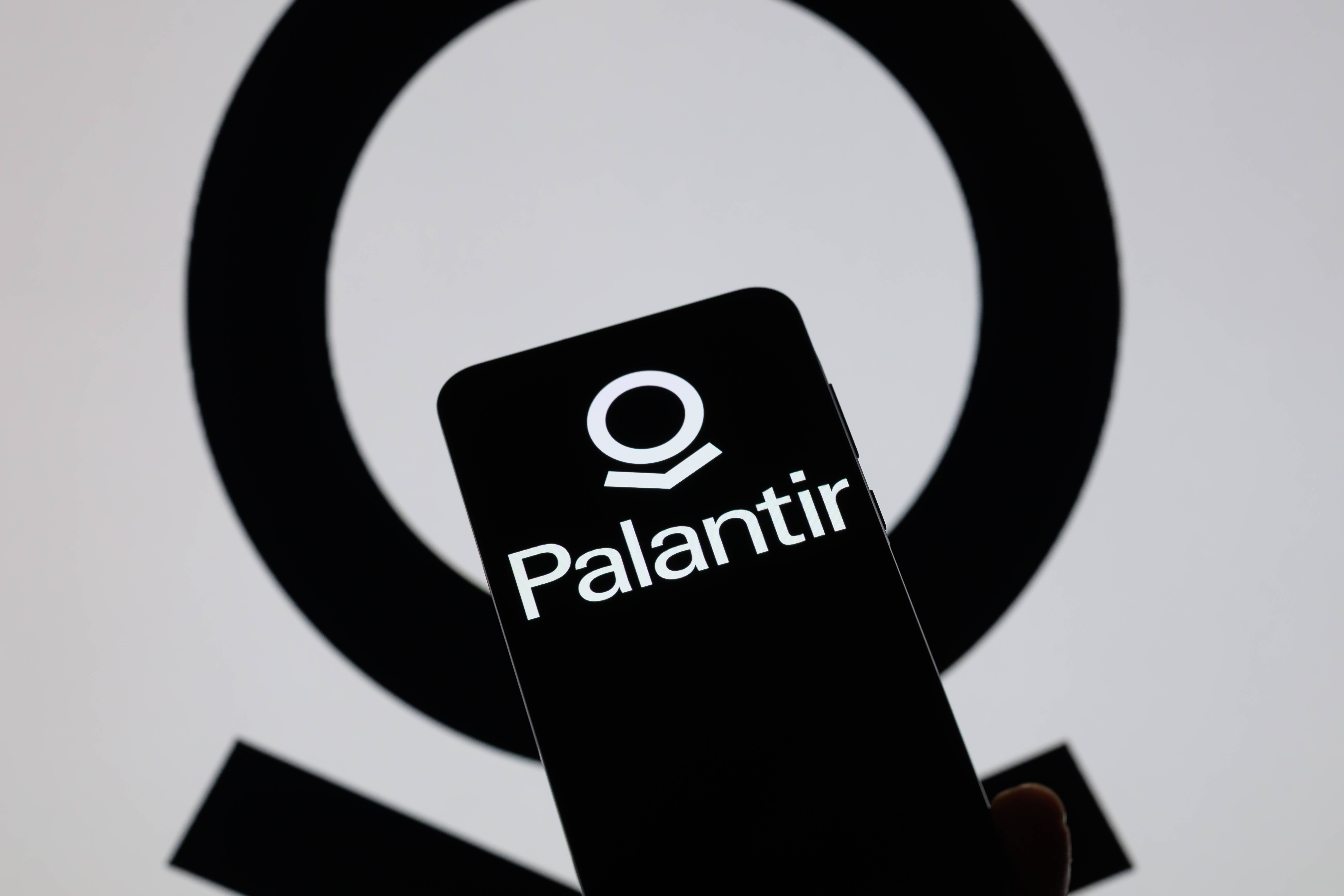 Ein schwarzer Handybildschirm mit dem Logo von Palantir.