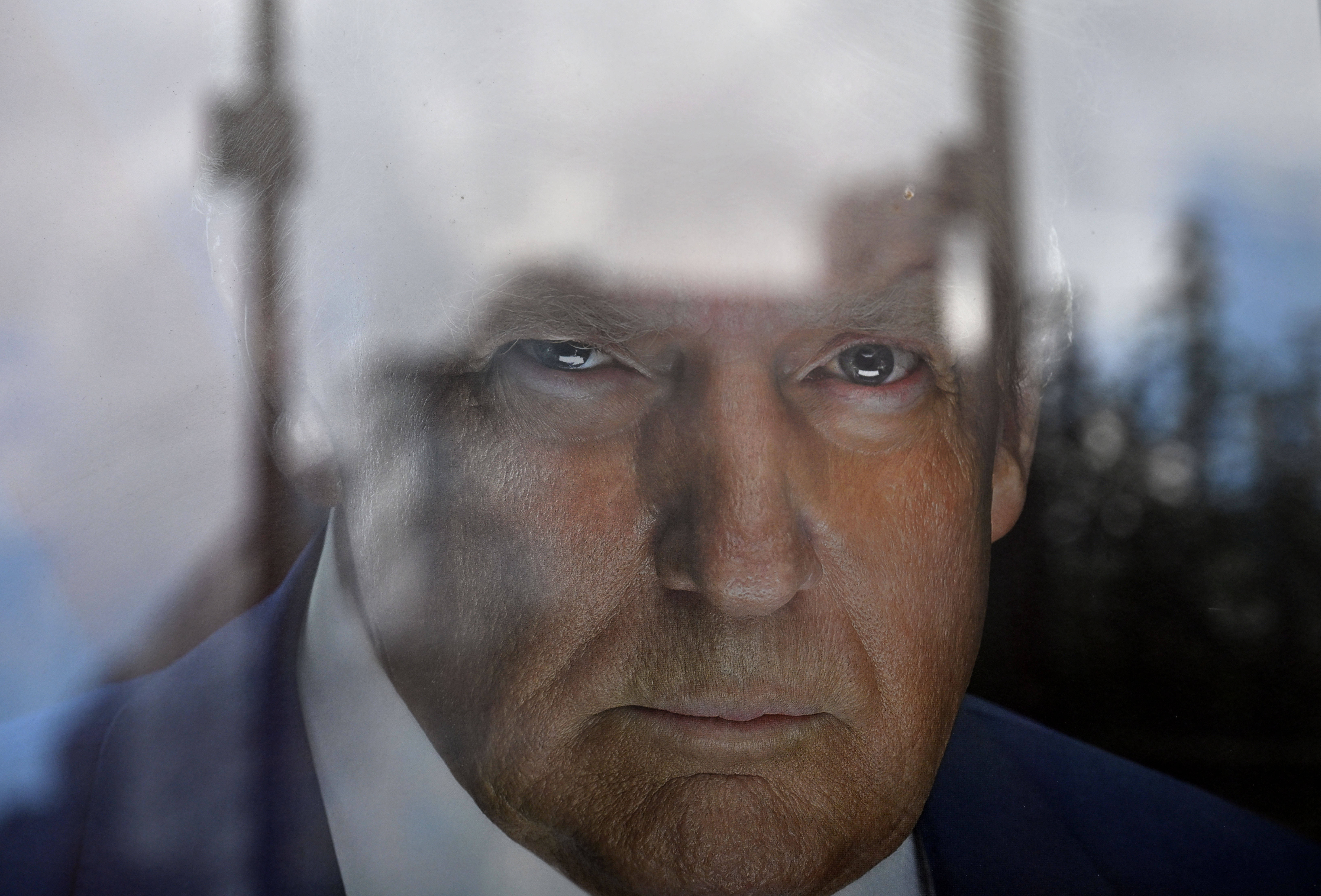 Foto eines Porträt von Donald Trump mit Reflexion der Glasscheibe in der oberen Bildhälfte
