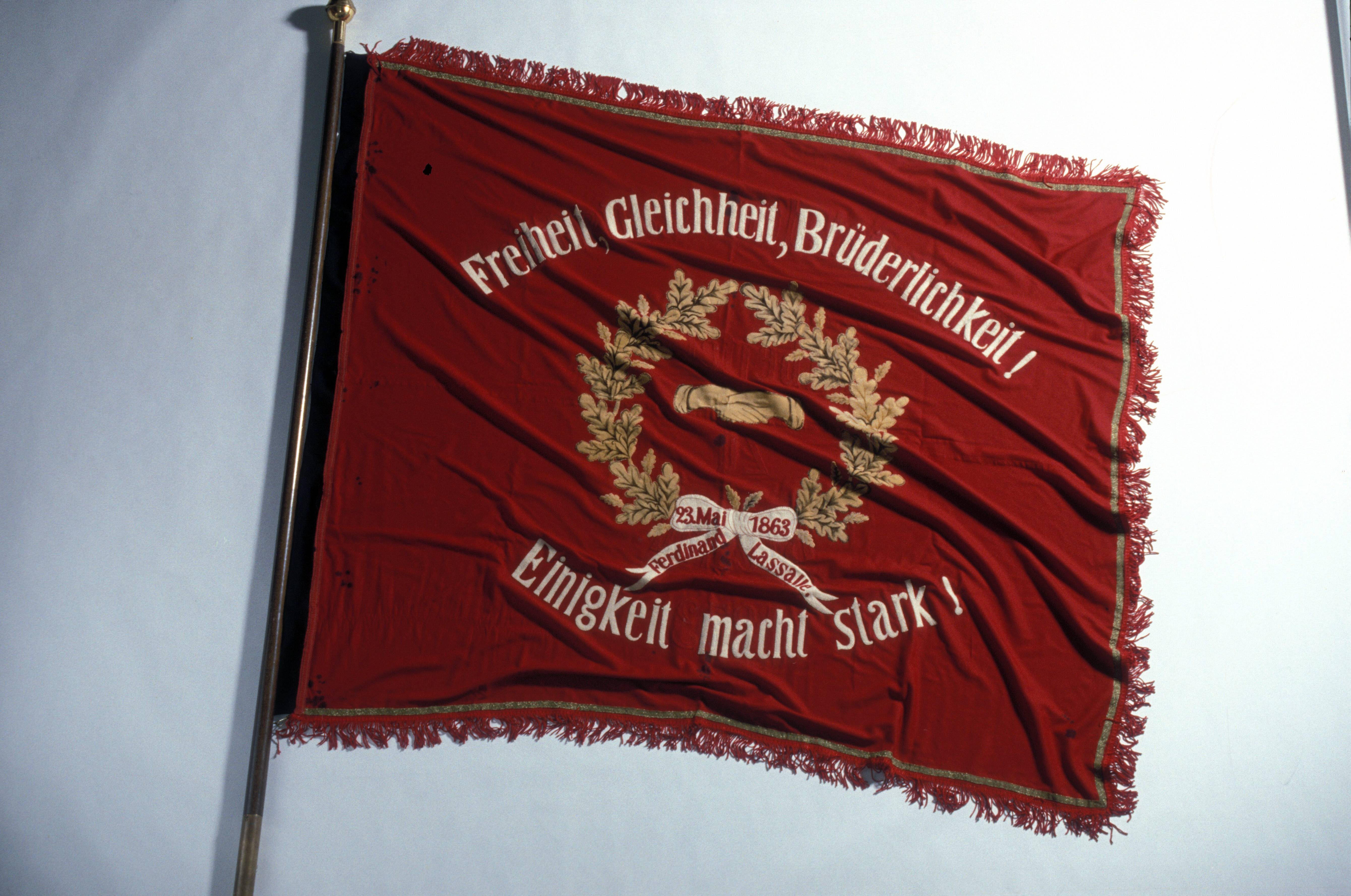 Freiheit, Gleichheit, Brüderlichkeit – Schriftzug auf der Breslauer Lassalle-Fahne des Allgemeinen Deutschen Arbeitervereins aus dem Jahr 1873. Der ADAV war zehn Jahre zuvor in Leipzig gegründet worden.
