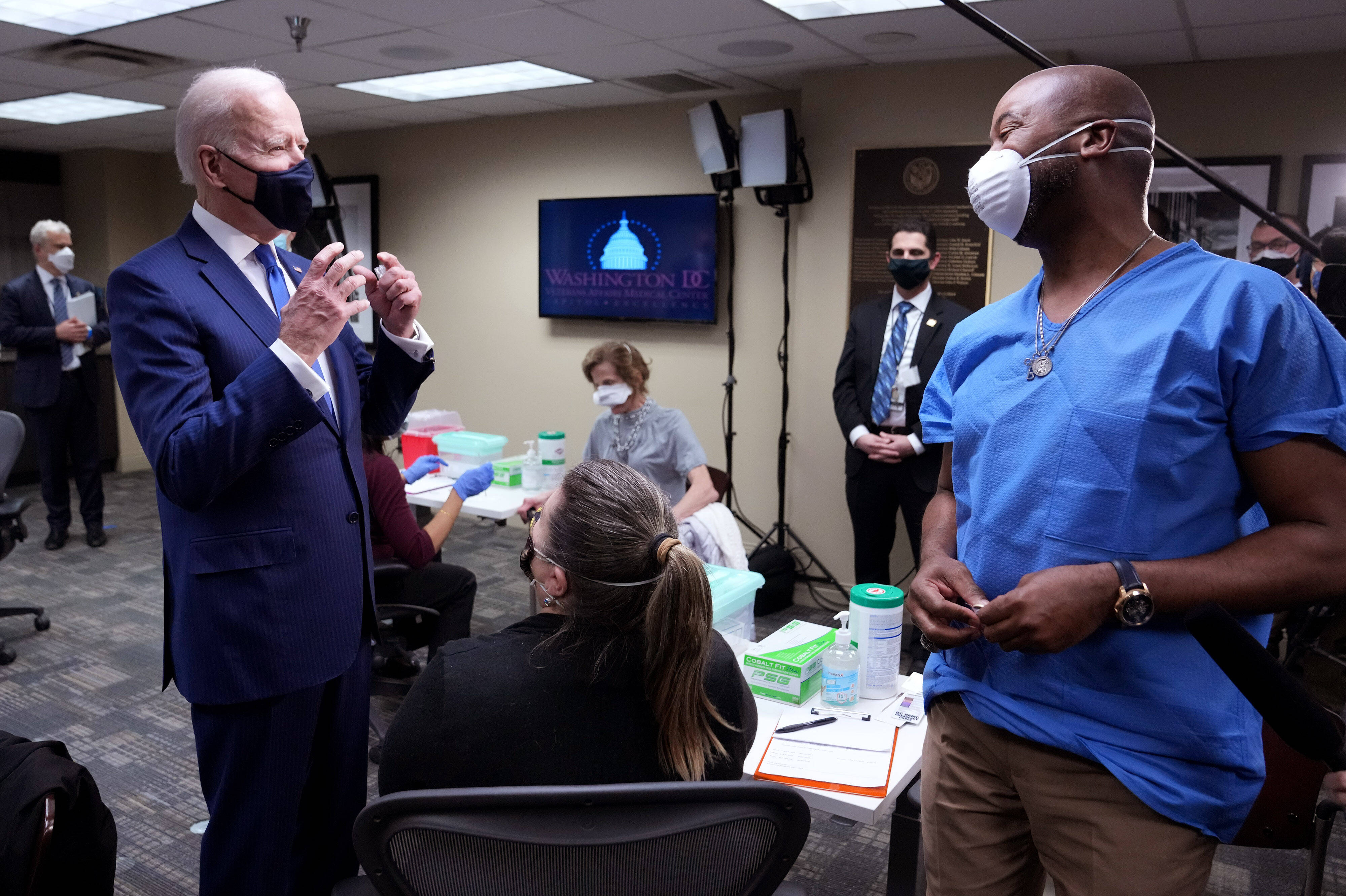 Joe Biden in einem Corona-Impfzentrum im Gespräch mit einem Impfwilligen.