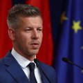 Porträt des designierten ungarischen Ministerpräsidenten Péter Magyar leicht von der rechten Seite aufgenommen; im Hintergrund eine ungarische und eine EU-Fahne