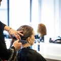 Eine Friseurin schneidet einer Kundin die Haare